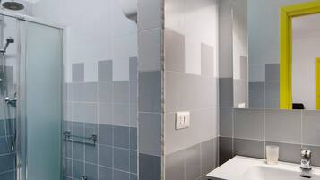 A modern bathroom with a shower, sink, and mirror.