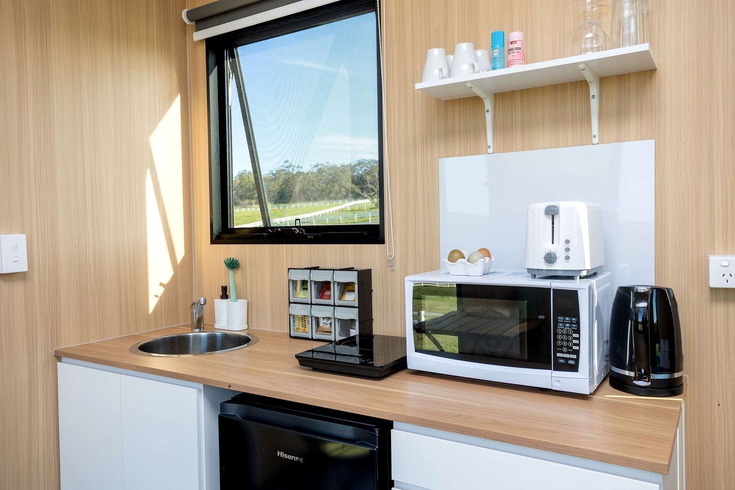 Cocina compacta con lavabo, microondas, tostadora y lavavajillas.