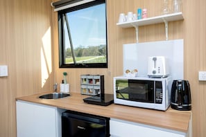 A compact kitchen with a sink, a microwave, a toaster, and a dishwasher.