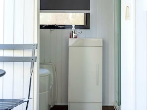 A compact bathroom with a toilet, a sink, and a cabinet.