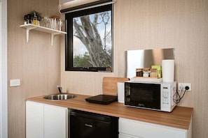 A compact kitchen with a sink, a microwave, and a dishwasher.