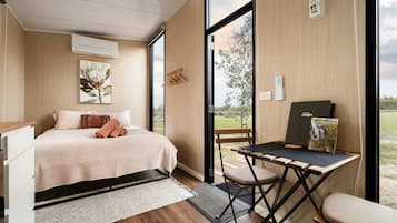 Une chambre à coucher avec un lit, un bureau et une vue sur l’extérieur.