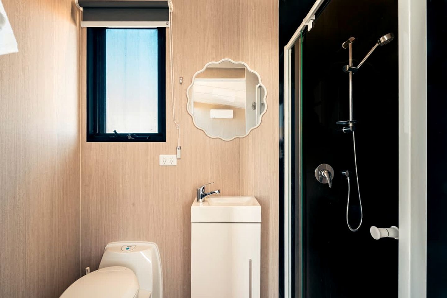 A modern bathroom with a toilet, sink, and shower.