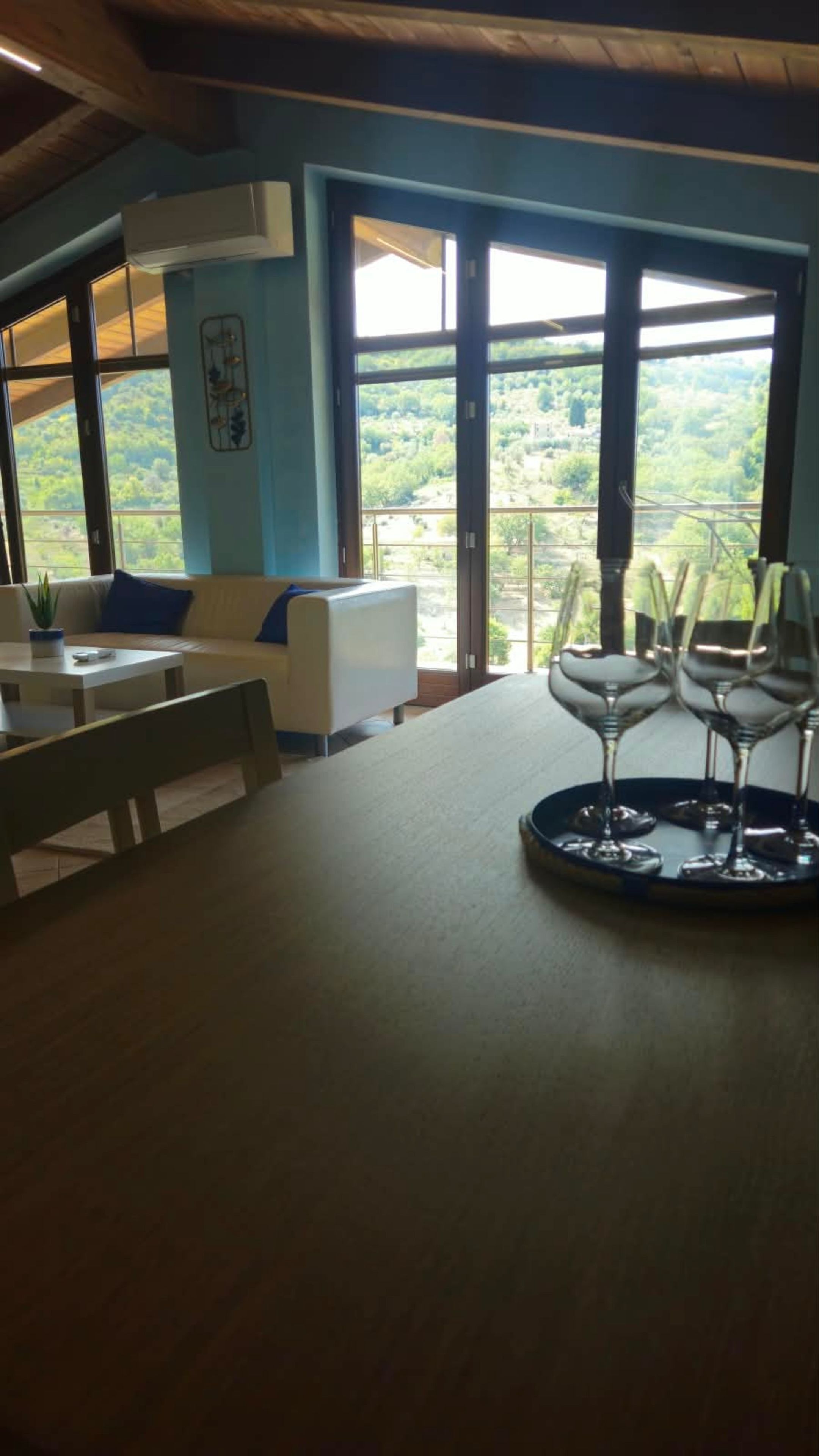 Un espace repas comprenant une table, des chaises et donnant sur l’extérieur.