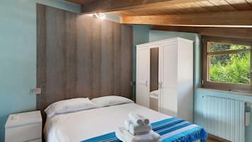 Una camera da letto con un letto, un armadio, una finestra vista e un termosifone.