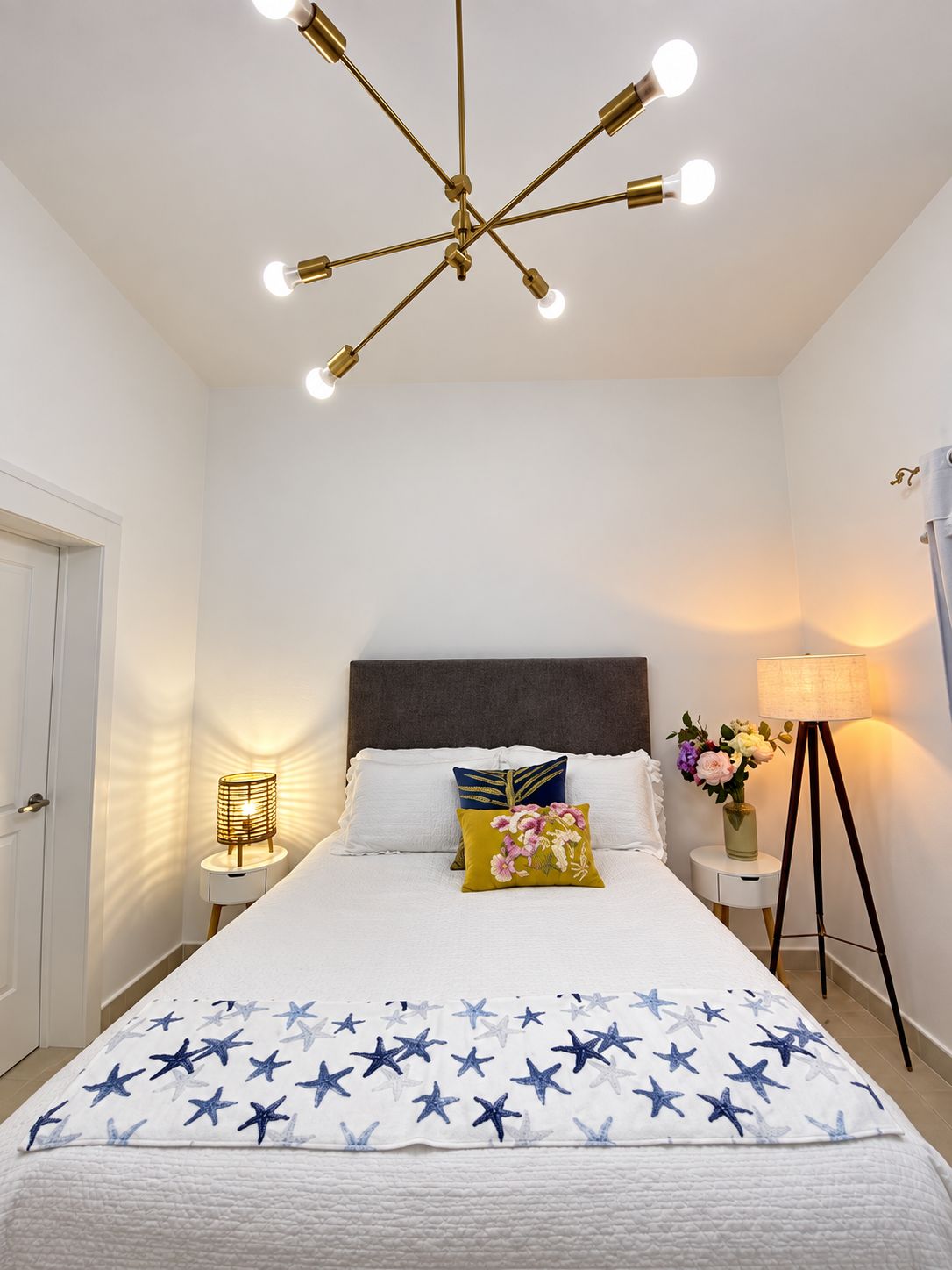 Ein Schlafzimmer mit einem Bett, Nachttischen, einer Stehlampe und einer Deckenleuchte.