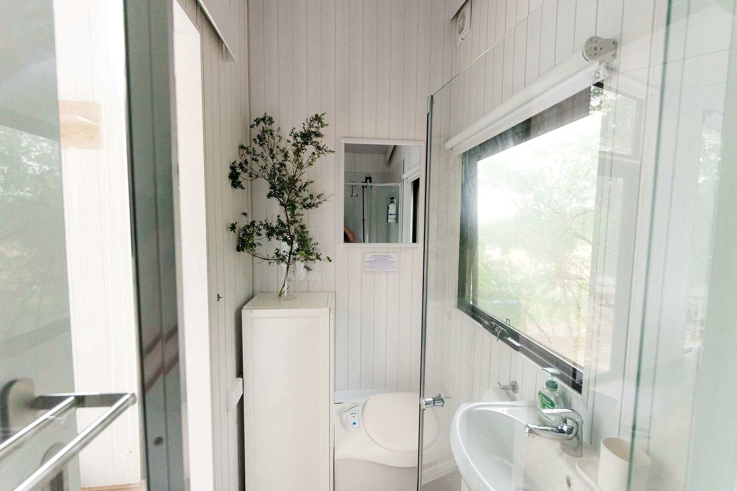 Une salle de bain avec des toilettes, un lavabo et une fenêtre.