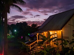 A house with a porch, a staircase, and a view of the sky at dusk. - Peaceful Eco-Farm A-Frame in Keaau,Volcano & Beach (Keaau)