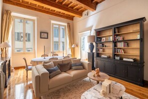 A living room with a sofa, coffee table, and bookshelf. - Tuscan Gold by MMega Homes and Villas (Florence)