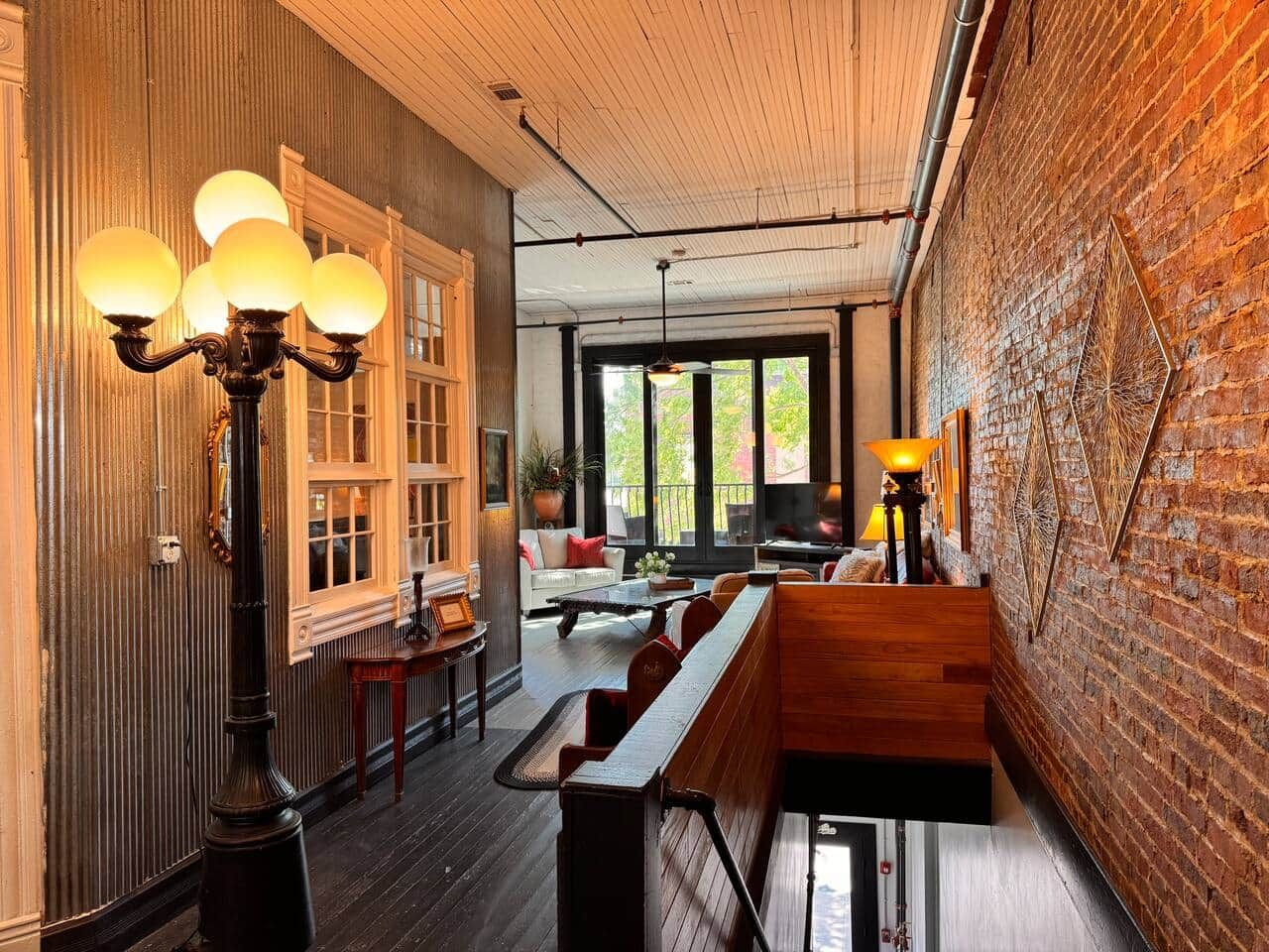 Un interior acogedor con un banco de madera, una mesa y una lámpara.