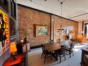 Un restaurante con pared de ladrillo, mesas y sillas de madera.