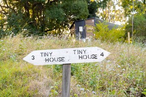 A directional signpost with 'Tiny House 3' and 'Tiny House 4' pointing in different directions.