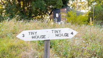 A directional signpost with 'Tiny House 3' and 'Tiny House 4' pointing in different directions.