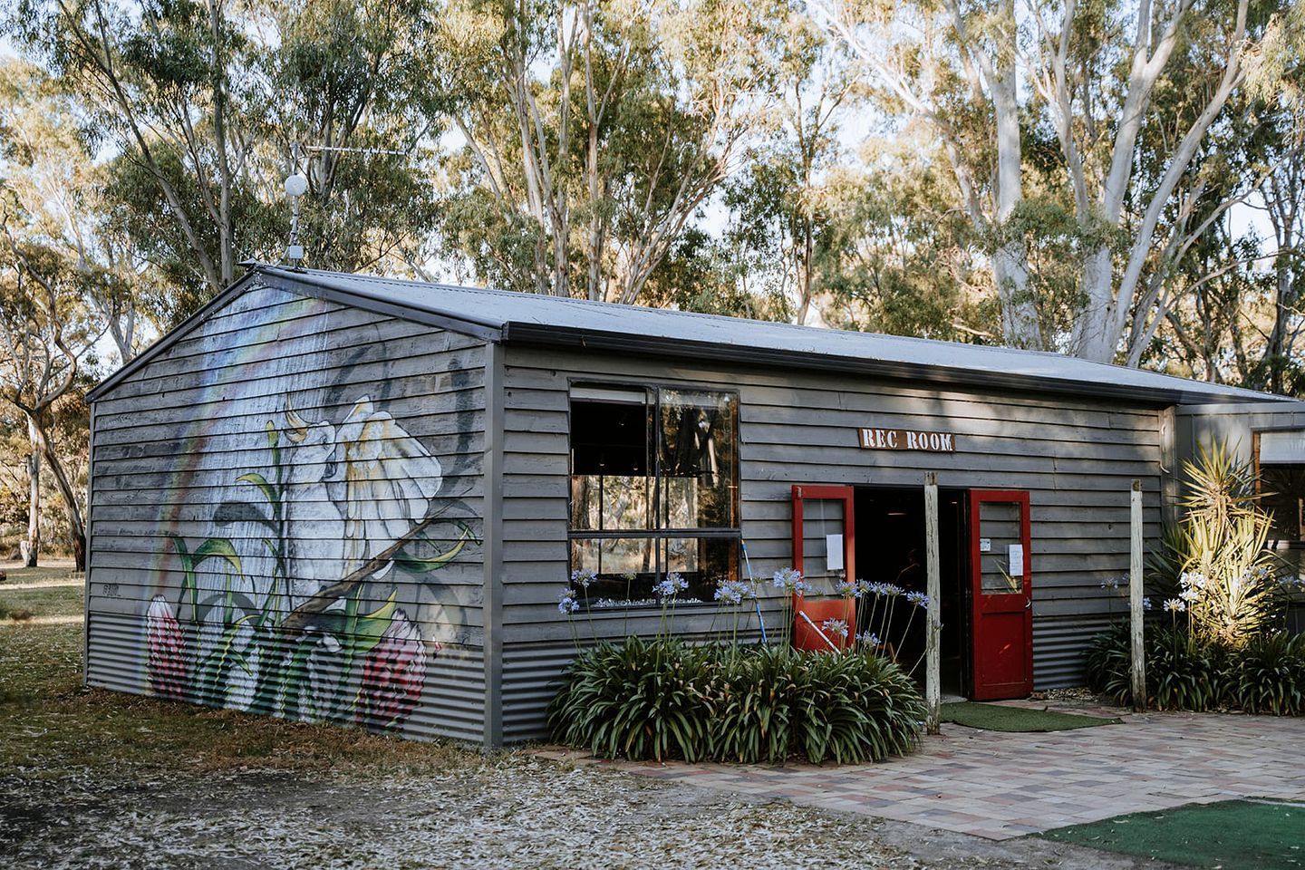 A small building with a 'REC ROOM' sign, a window, and a door.