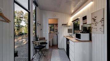 Una cocina compacta con comedor, vistas al exterior y una pequeña isla con pileta.