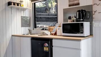 A compact kitchen with a built-in microwave, a coffee maker, and a dishwasher.