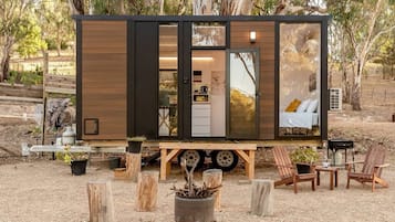 Een moderne, compacte stacaravan met een keukenhoek, een slaapgedeelte met een bed en een eethoek.
