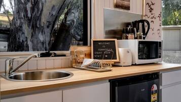A kitchen with a stainless steel sink, a coffee maker, a microwave, and a sign that reads 'WELCOME TO SUMMERLEA ENJOY YOUR STAY'.