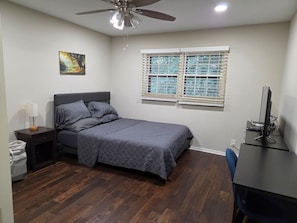A bedroom with a bed, a desk, a chair, a ceiling fan, a window with blinds, and a wall-mounted artwork. - Spacious 4-bedroom apartment in a safe, quiet and matured Neighborhood (Doraville)