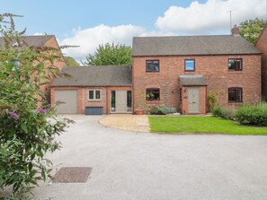 A two-story brick house with a front driveway, a garage, and a small garden area. - 7 Forge Close (Derby)