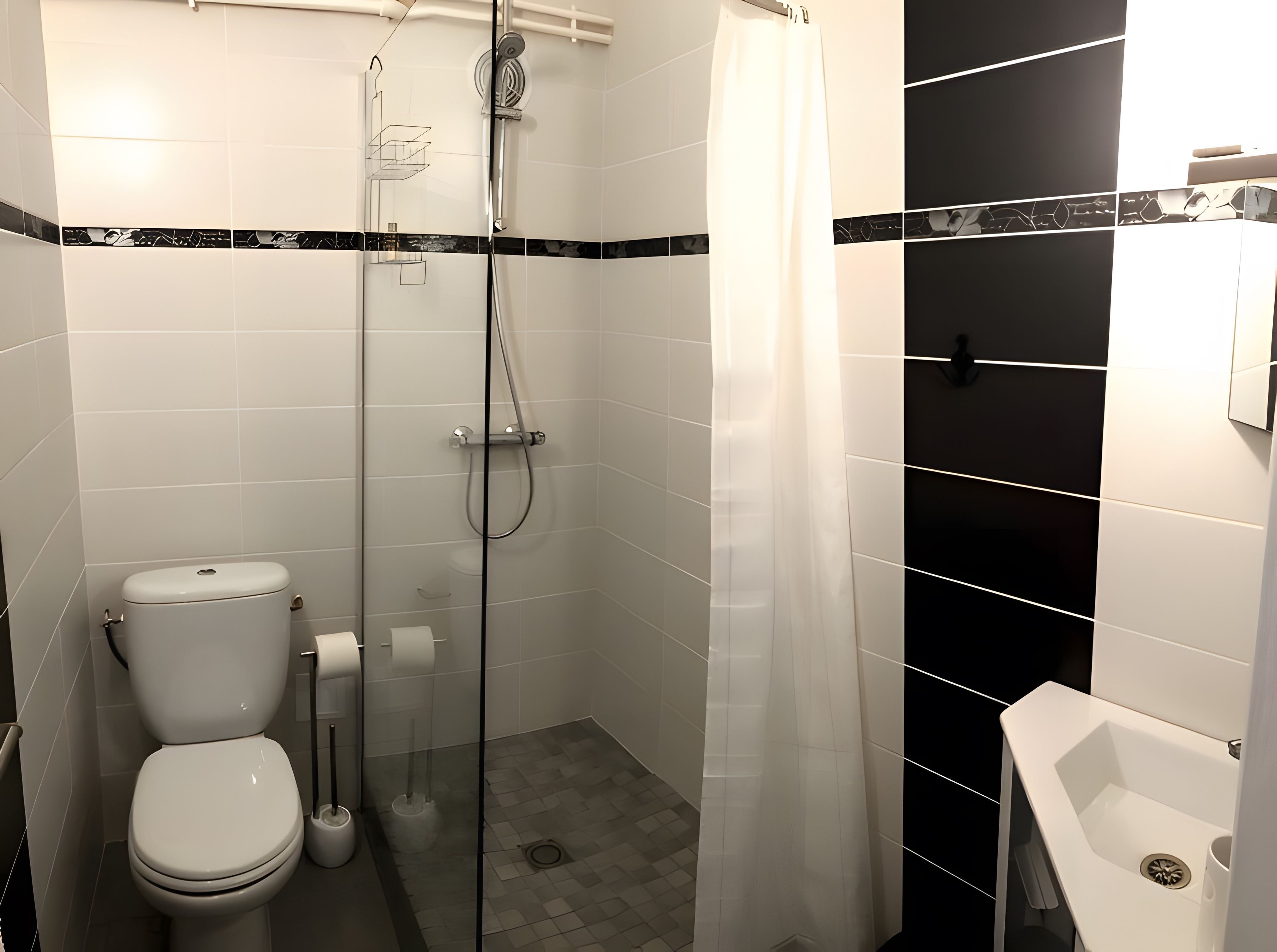 A modern bathroom with a glass-enclosed shower, a toilet, and a sink.