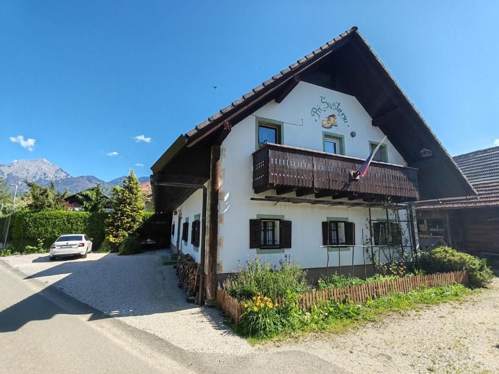 A traditional Alpine-style building with a sloped roof, a balcony, and a sign indicating it is a restaurant.