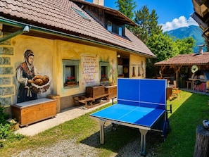 A traditional building with a mural, a ping pong table, and outdoor seating. - Apartment Ursa Major & Glamp Barba (Preddvor)