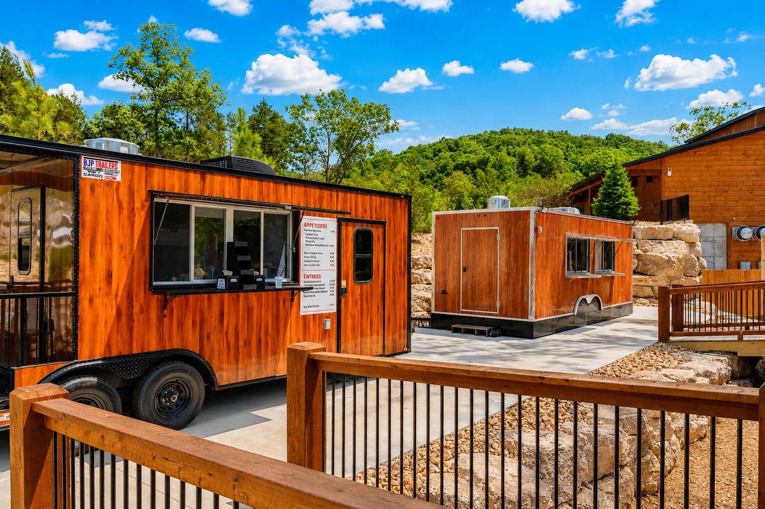 Un camion-restaurant en bois, aménagé comme un véhicule récréatif, avec un panneau affichant le menu, est stationné dans un espace paysager agrémenté d’une clôture en bois et d’un bâtiment en arrière-plan.