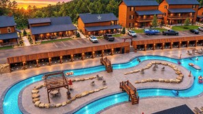 Een resort met een zwembad, terras en meerdere gebouwen.