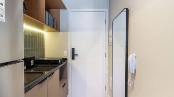 Una cocina compacta con microondas, horno empotrado y una pequeña encimera.