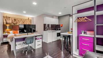 A modern bedroom with a bed, bedside table, and a cityscape wall art.
