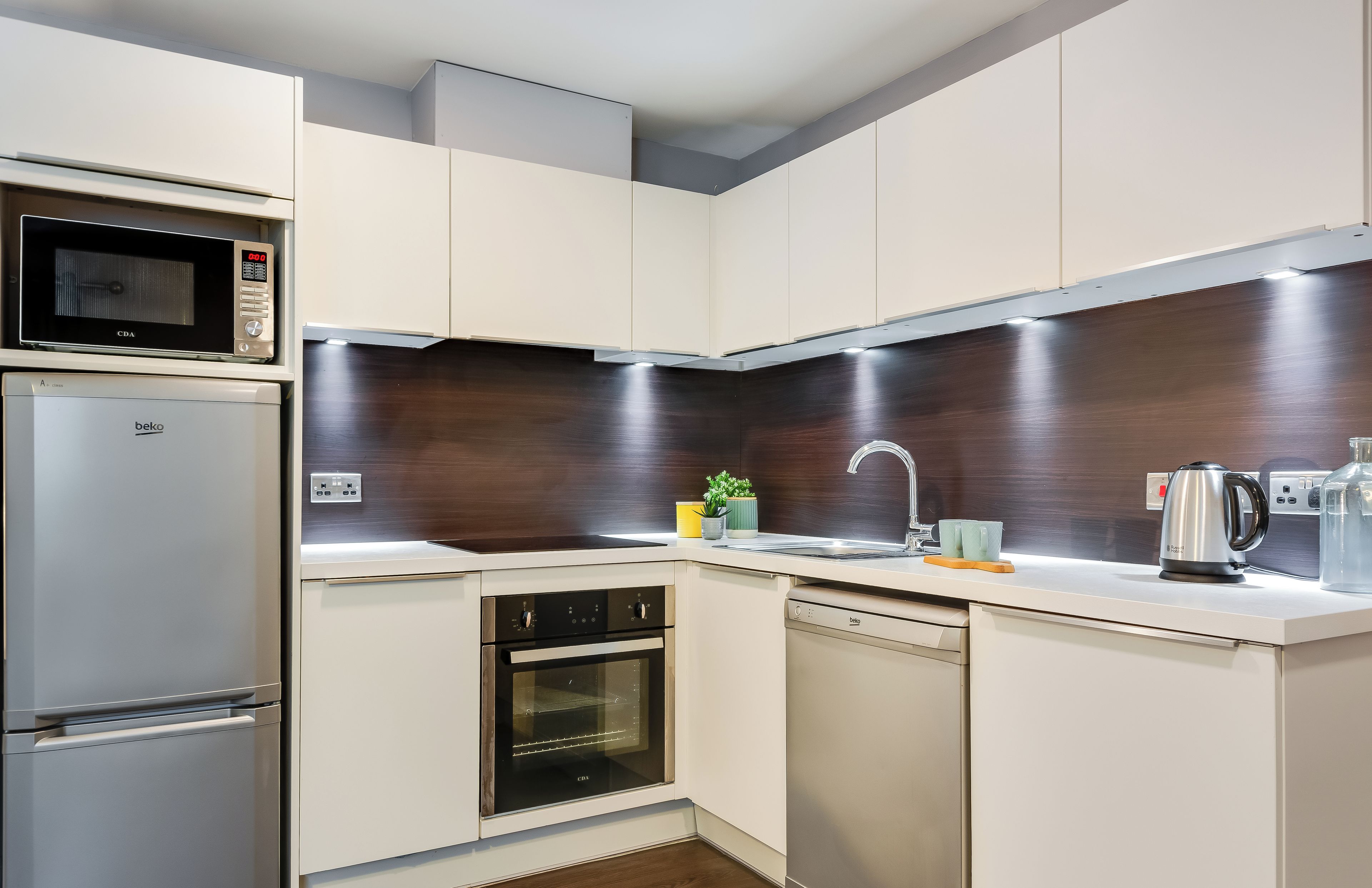 A modern kitchen with built-in appliances, a microwave, oven, and dishwasher.