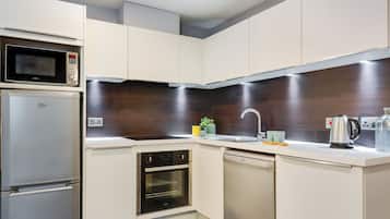 A modern kitchen with built-in appliances, a microwave, oven, and dishwasher.