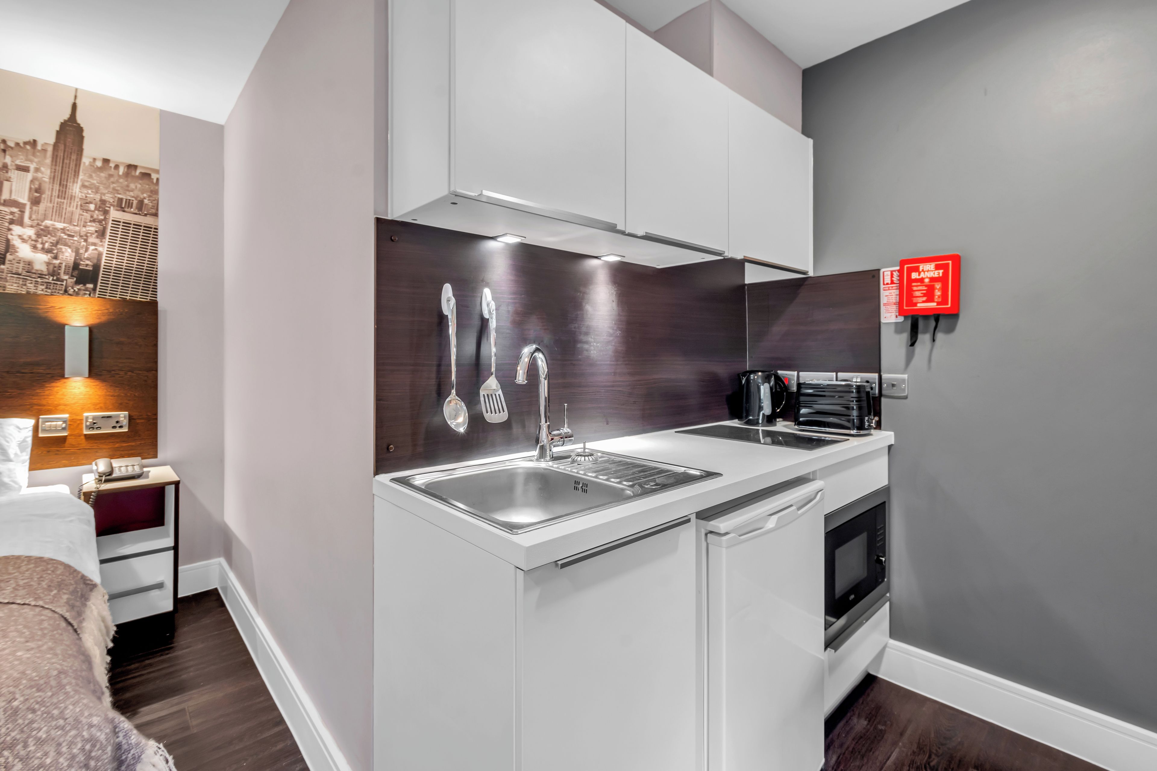A modern kitchen with a built-in sink, stainless steel faucet, and a coffee machine.