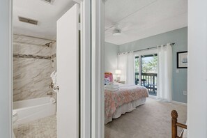 Ein Schlafzimmer mit einem großen Bett, ein Badezimmer mit einer Badewanne und ein Balkon mit Blick.