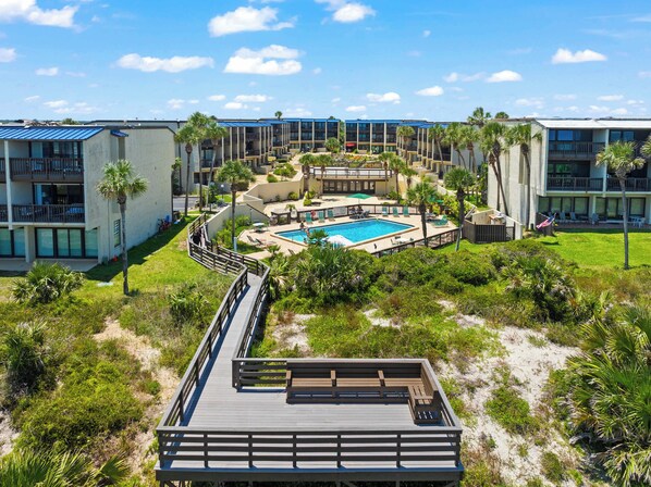 Ein Resort mit Schwimmbad, mehreren Gebäuden und einer Promenade.