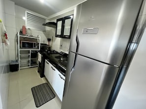 Cozinha moderna com eletrodomésticos de aço inoxidável, micro-ondas e fogão a gás.