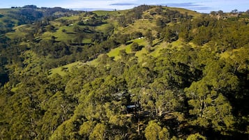 Un paysage vallonné, avec une forêt dense et des bâtiments dispersés.