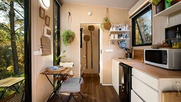 Cocina compacta con comedor, piso de madera y vistas al exterior.