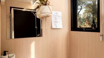 A compact bathroom with a toilet, sink, and a mirror above the sink.