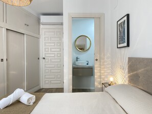 A hotel room with a bed, a bathroom with a sink, and a wardrobe. - Apartment in Nerja Near Torrecilla Beach (Nerja)