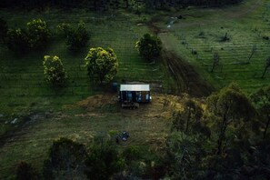 A rural property with a small cabin, a dirt path, and sparse vegetation.