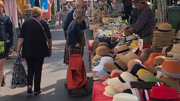 A market with various stalls, including one with hats on display.