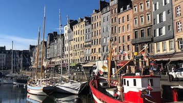 A waterfront with colorful buildings, a dock with boats, and a clear sky.