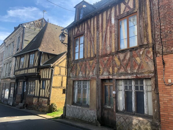 Une rangée de bâtiments traditionnels à colombages, dont on peut voir la maçonnerie en briques et la structure en bois.