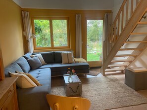 Un salon avec un canapé, une table basse et un escalier.