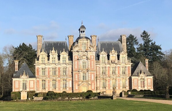 Un grand bâtiment historique doté de nombreuses tours et d’une façade symétrique.