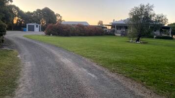 A gravel driveway leading to a house with a garage and a covered porch.
