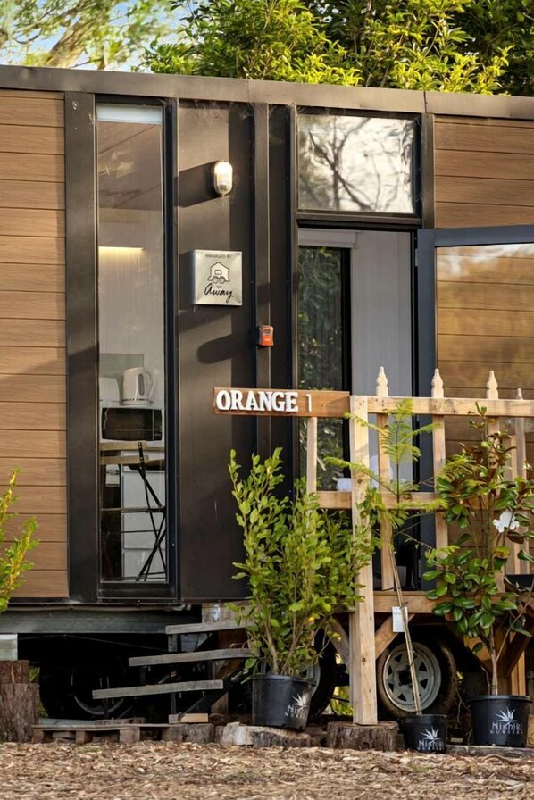 A train car with a sign reading 'ORANGE 1' and a 'MANAGED BY Away' sign.
