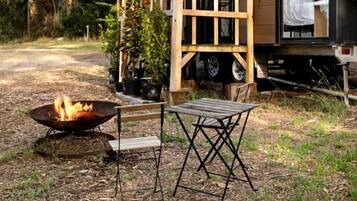 Eine moderne Blockhütte mit einer Terrasse, einer Feuerstelle und einem Tisch.
